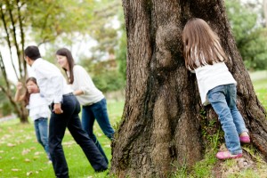 Happy family playing hide and seek at the park